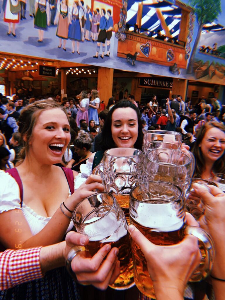 Photo of female au pair friends all together cheersing at Oktoberfest