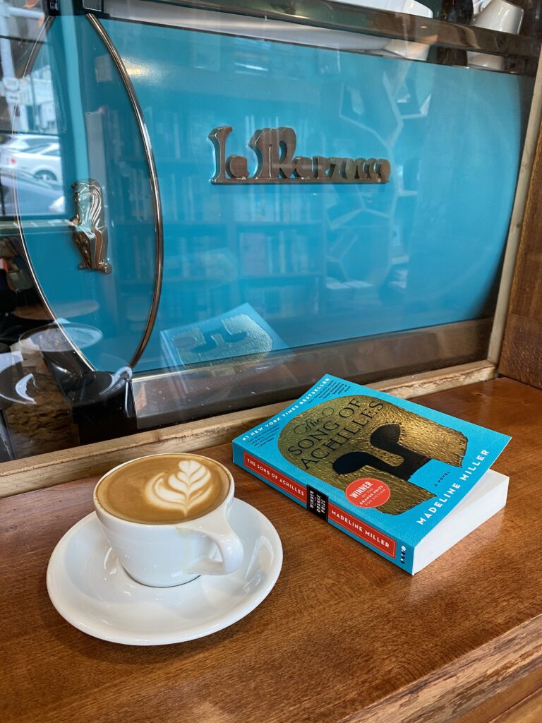 Latte and book in front of Espresso Machine