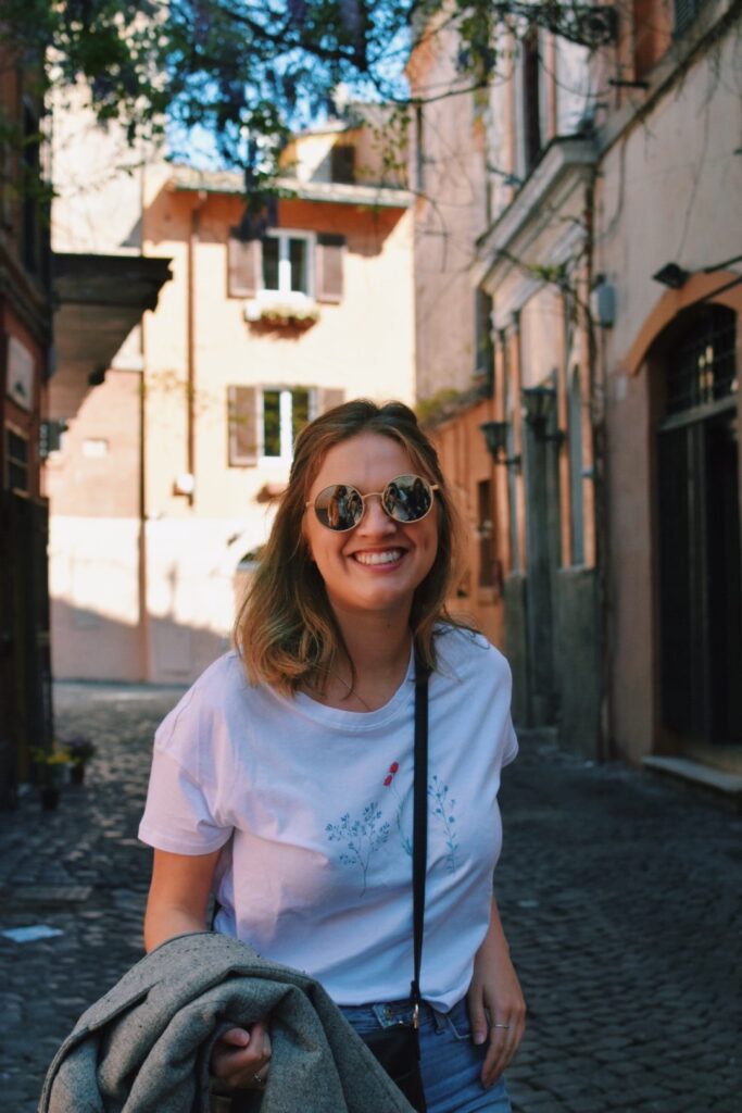 Mariah smiling in front of a beautiful alley way in Rome Italy