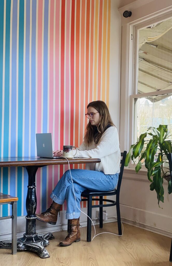 Mariah, 20-something woman, sitting at a table, working on her computer at Te Chai Te Teahouse, or Portal Tea, in NW Portland.